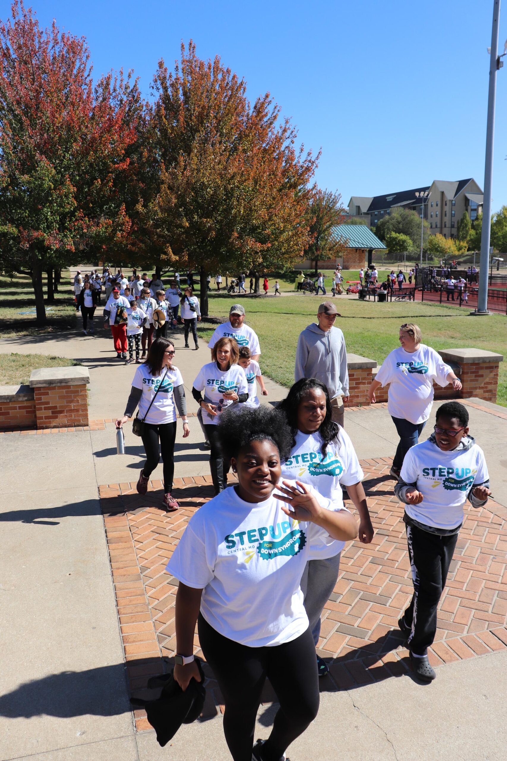 Team Walking In Park Smiling And Waving